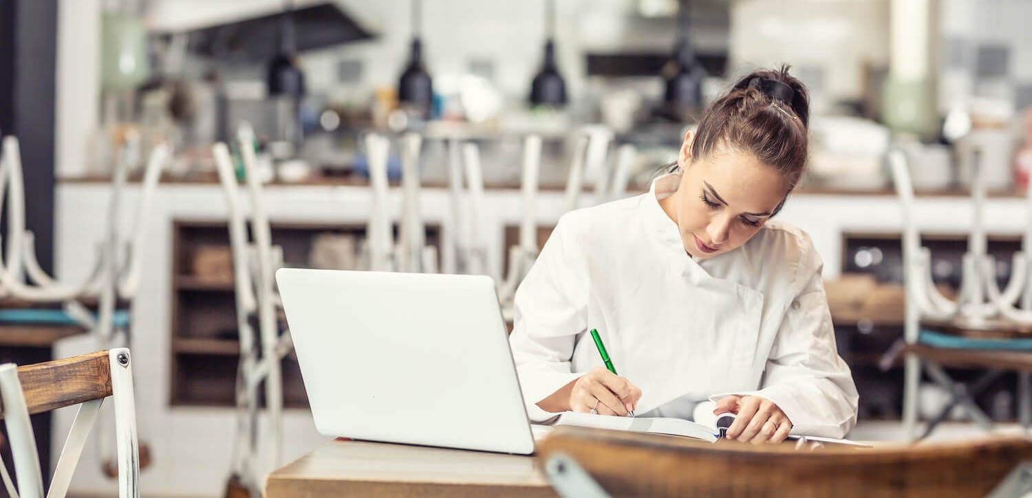 female chef doing paperwork after close