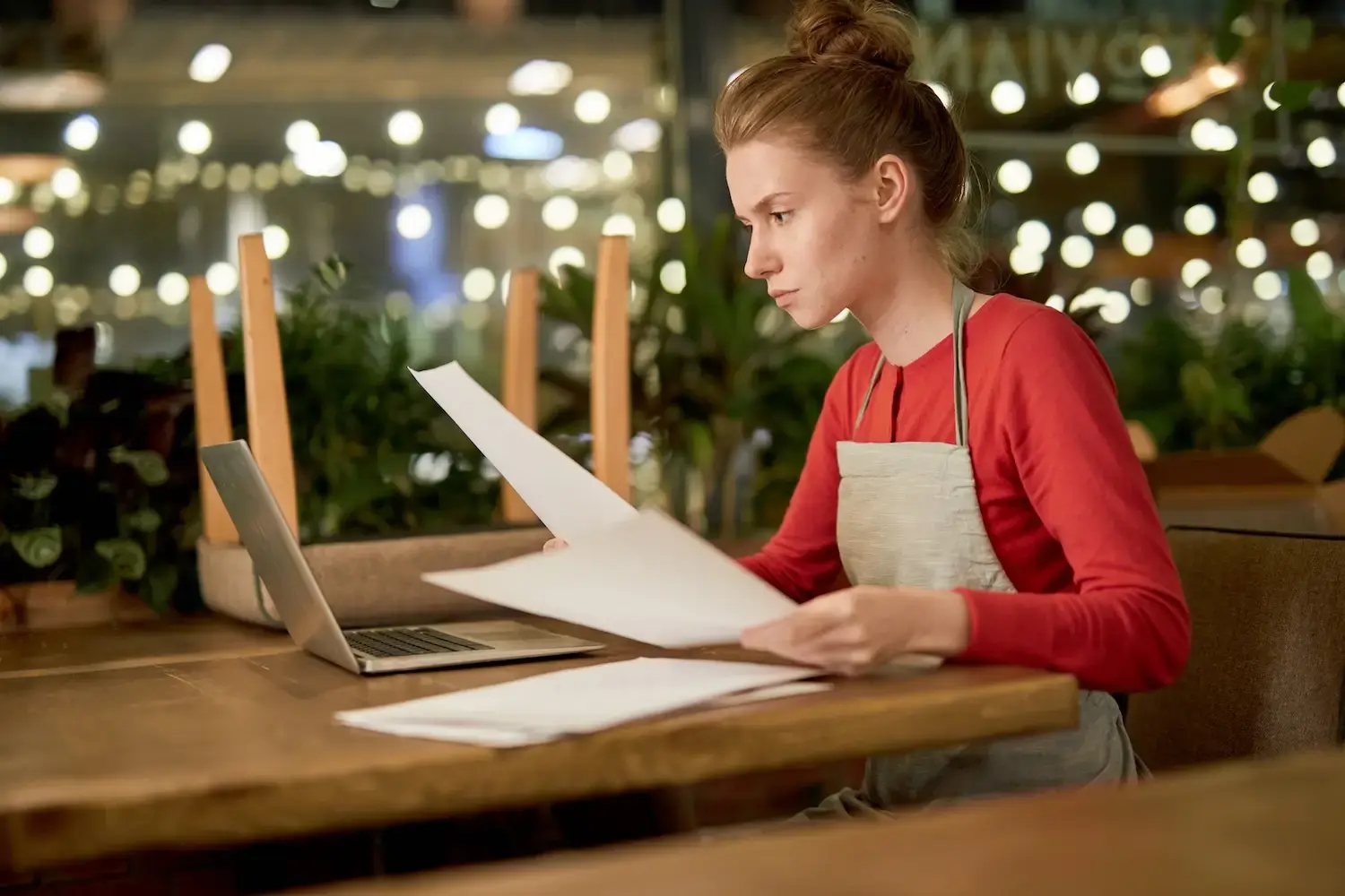 Cafe staff doing paperwork on laptop