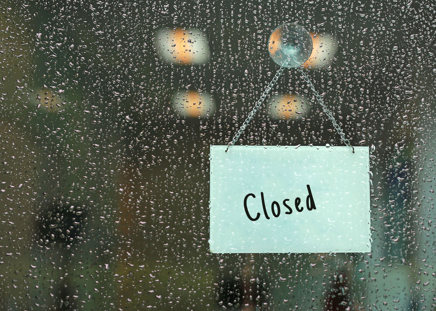 Closed sign on rainy door